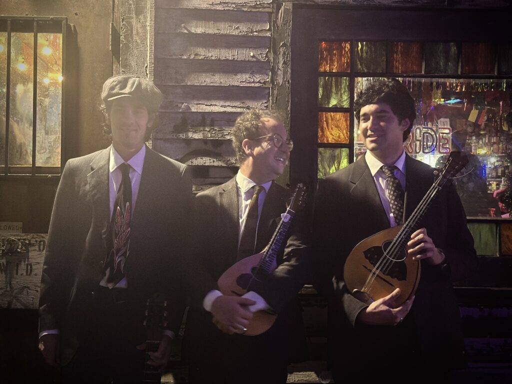 three men holding acoustic instruments