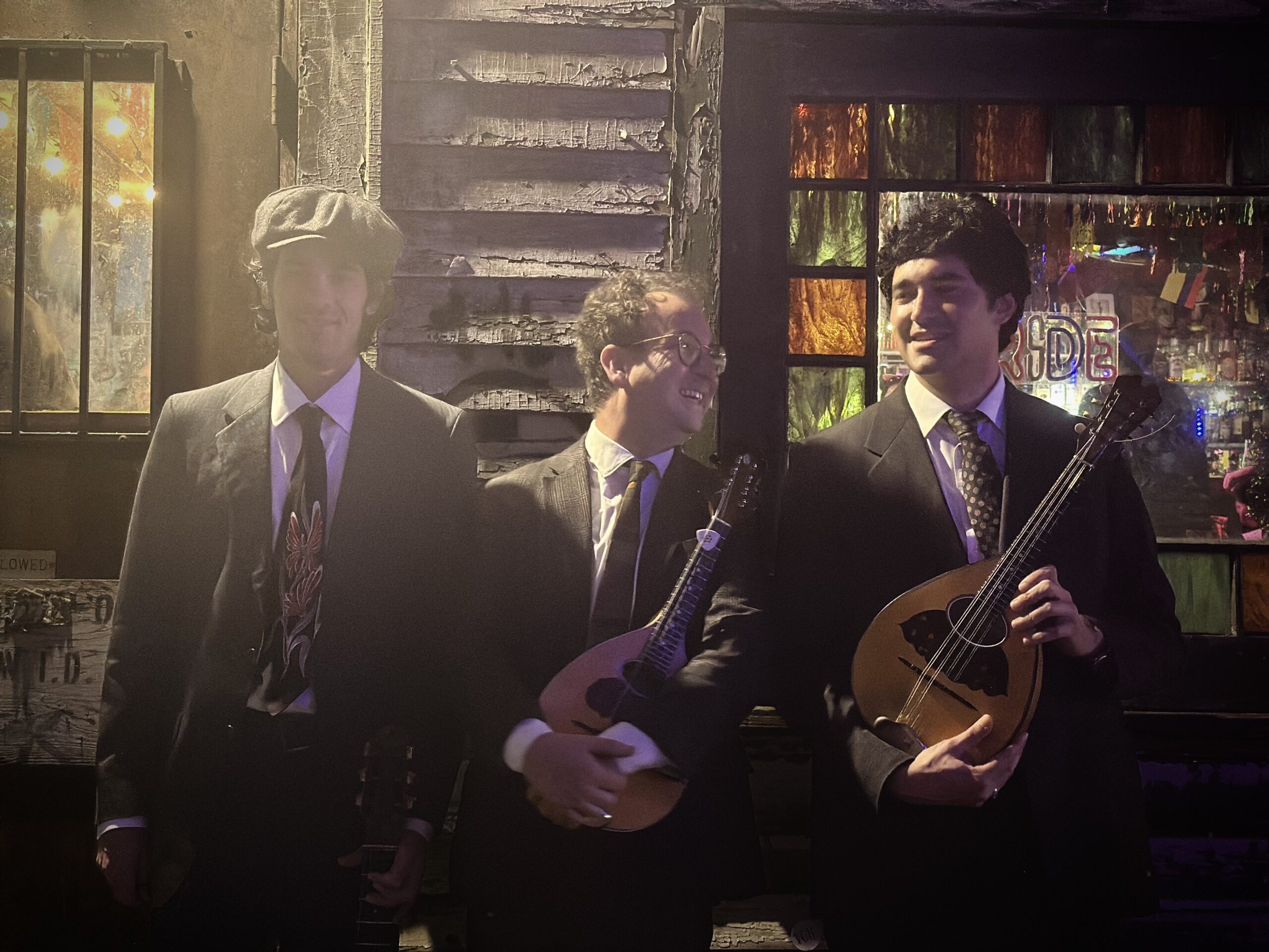 three men holding acoustic instruments