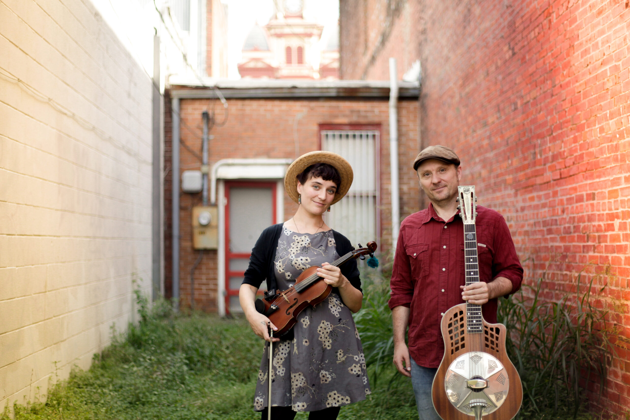 Photo of the Silver Lining Serenaders holding their instruments outdoors in a courtyard.